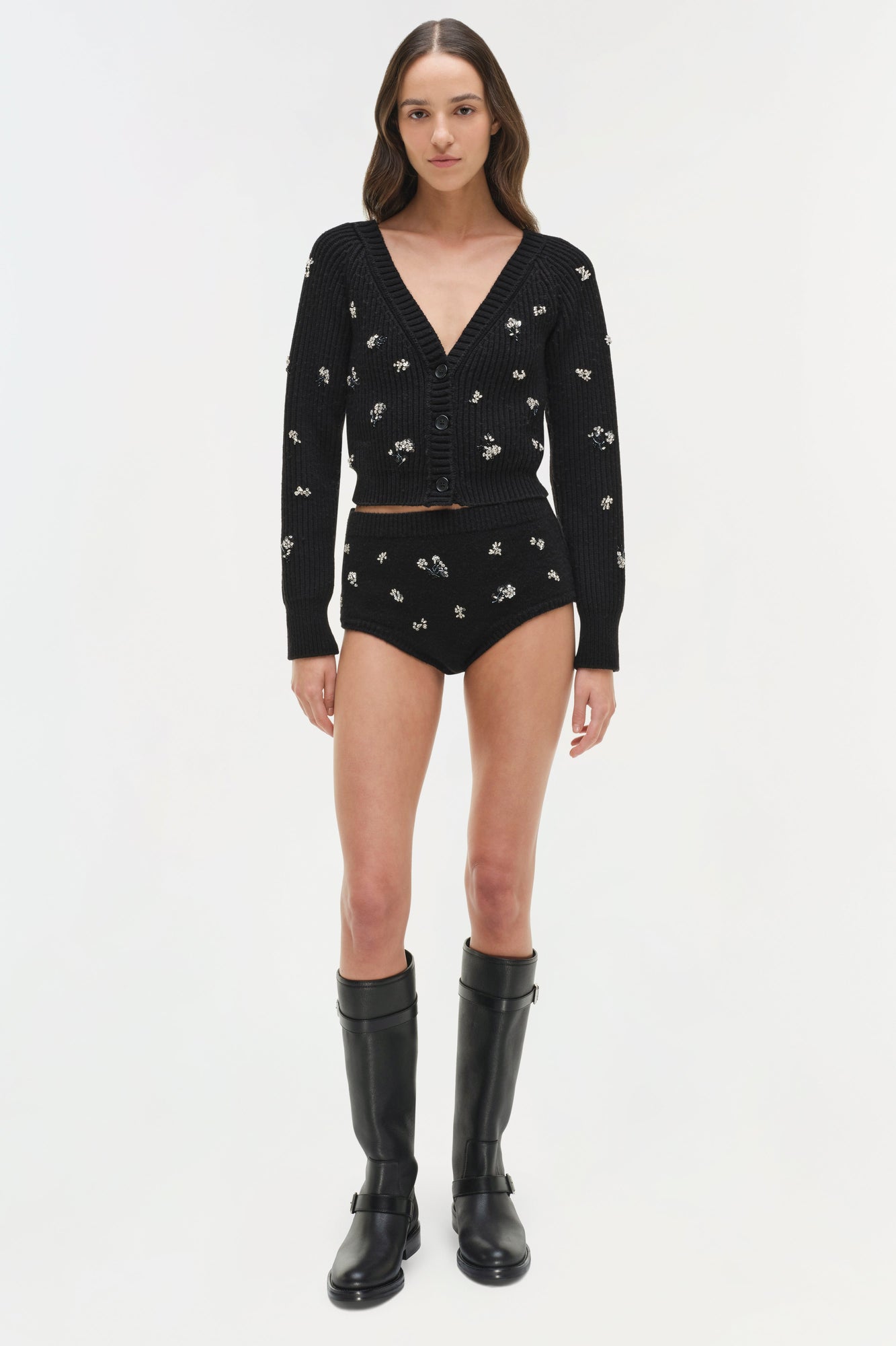Black ribbed cardigan with silver floral embellishments, V-neckline, and button front, styled with matching shorts and black 