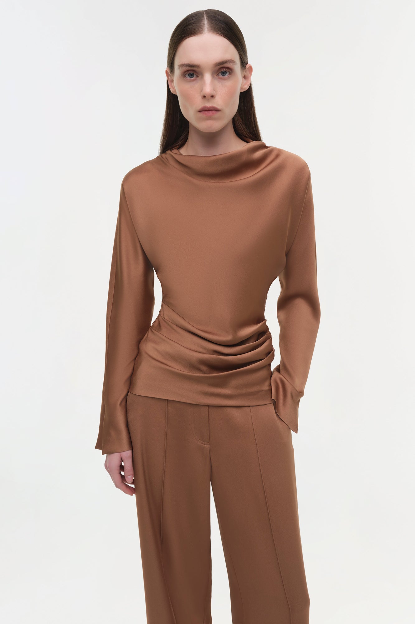 Brown satin top with draped cowl neckline and ruched side detail worn with matching trousers.