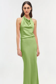 Woman wearing a lime green satin halter gown with draped neckline and fitted skirt.