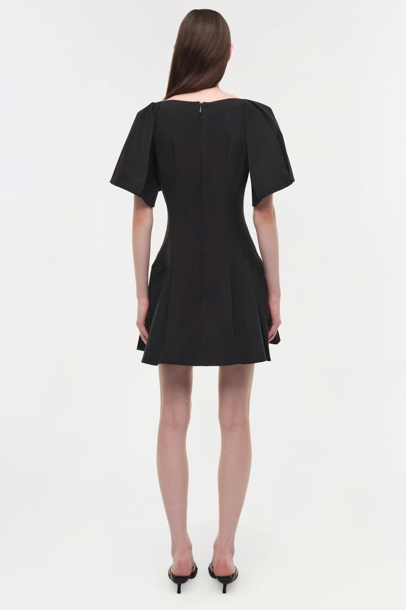 Black mini dress with short puffed sleeves and a fitted bodice with pleated skirt detail, shown from back view.