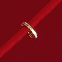 Model. Close up of diamond eternity ring wrapped around red string on red background