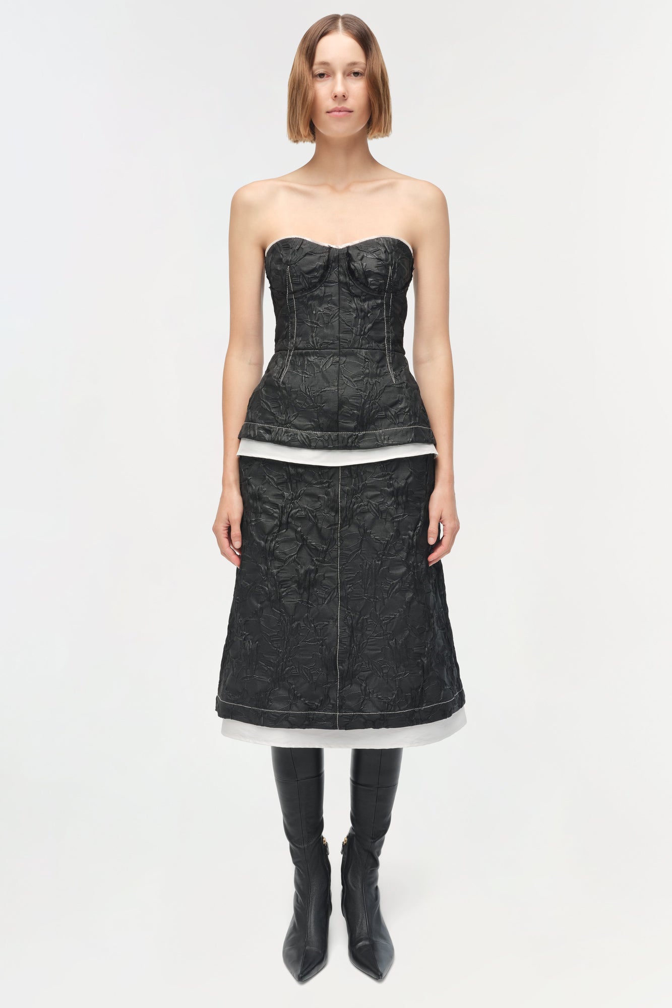 Black jacquard midi skirt with white waistband trim, worn with matching corset top and black boots.