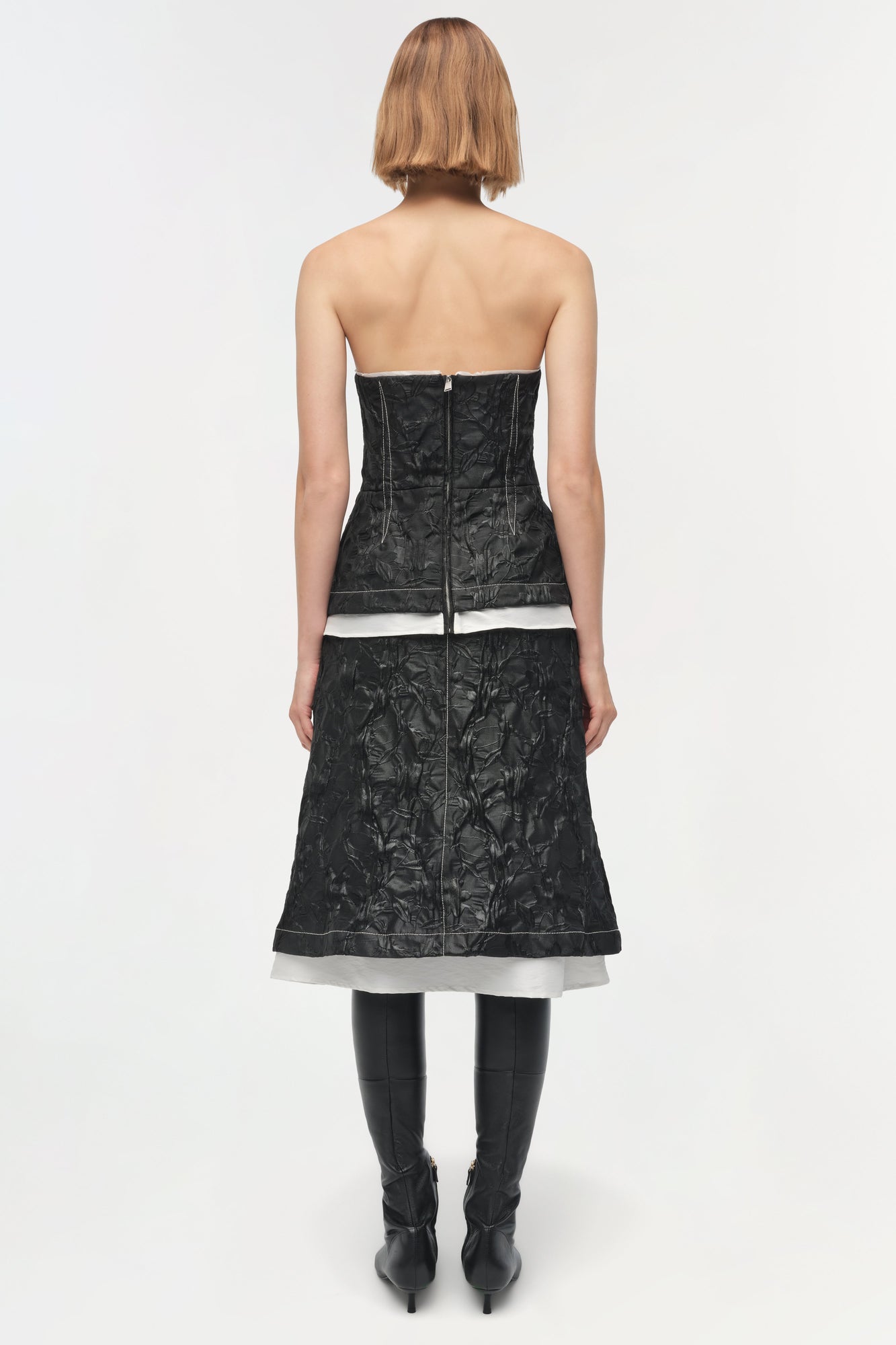 Black jacquard midi skirt with white stripe detail, worn with black boots, shown from back view.