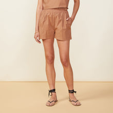 Front view of model wearing the poplin paperbag shorts in sahara.