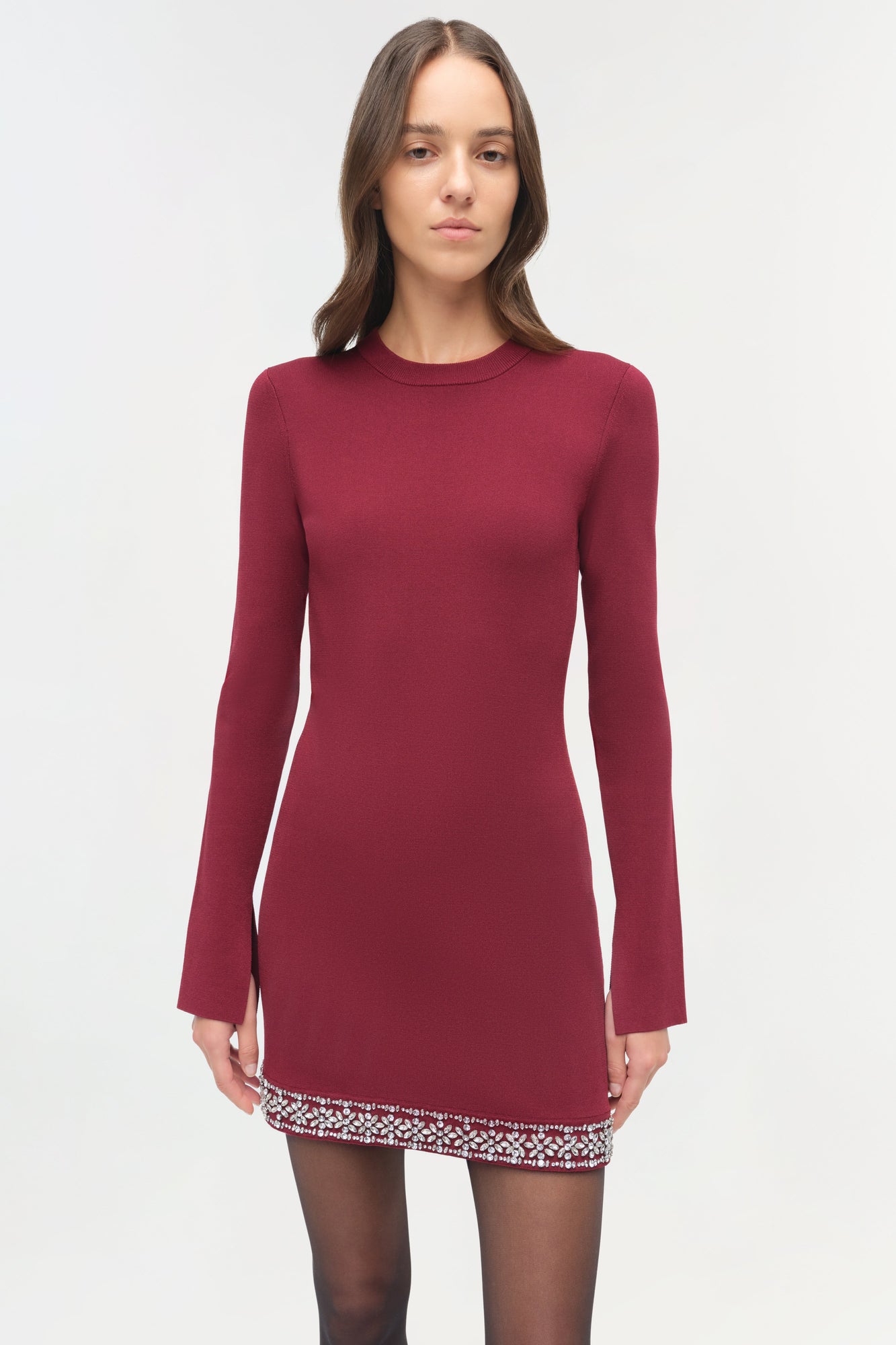Burgundy knit mini dress with long sleeves and embellished trim at the hemline.