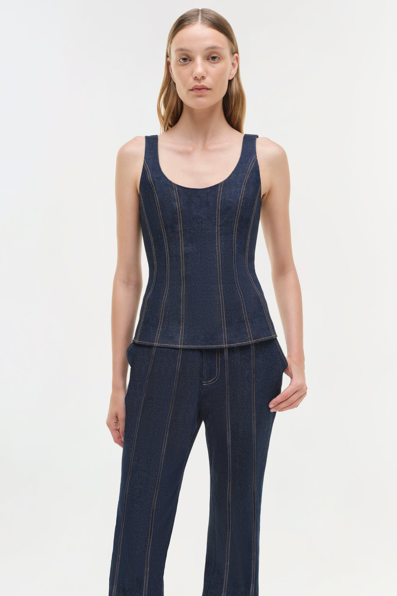 Dark blue denim bustier top with contrast topstitching worn with matching denim pants.