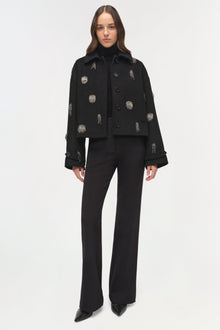 Black cropped jacket with silver embellished details and matching wide-leg trousers.