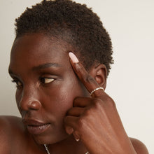 Model. Close-up of a person with their hand near their face on a neutral background