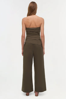 Olive green strapless cotton bustier top with ruched detailing, shown on model from back view.