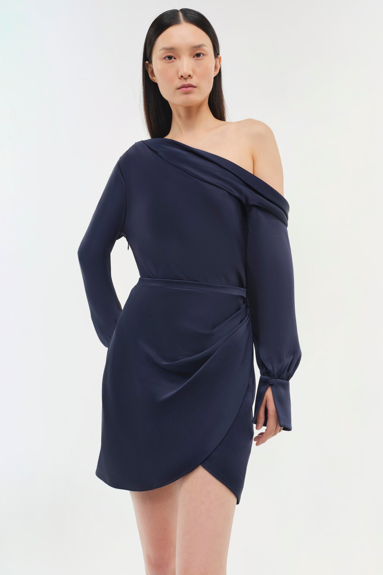 Dark navy one-shoulder wrap dress with long sleeves and asymmetrical hemline.