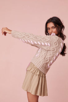 Sweater with chunky Peruvian cable detailing and a charmeuse ribbon threaded throughout.