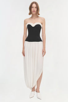 Black and white strapless dress with sweetheart neckline, fitted bodice, and asymmetrical draped skirt.