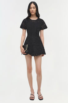 Black mini dress with eyelet embroidery, scalloped hem, and short flutter sleeves.