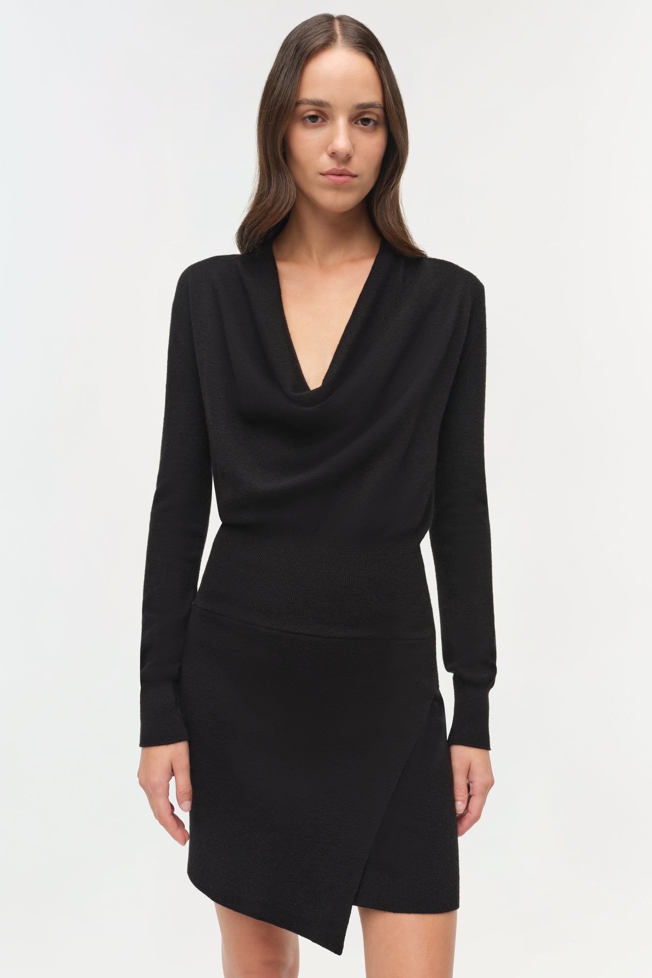 Black wool mini dress with draped cowl neckline and long sleeves on model.