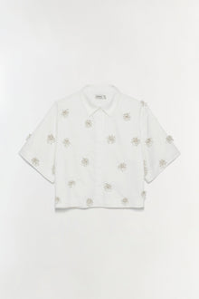 White camp shirt with scattered tan palm tree embellishments and short sleeves.