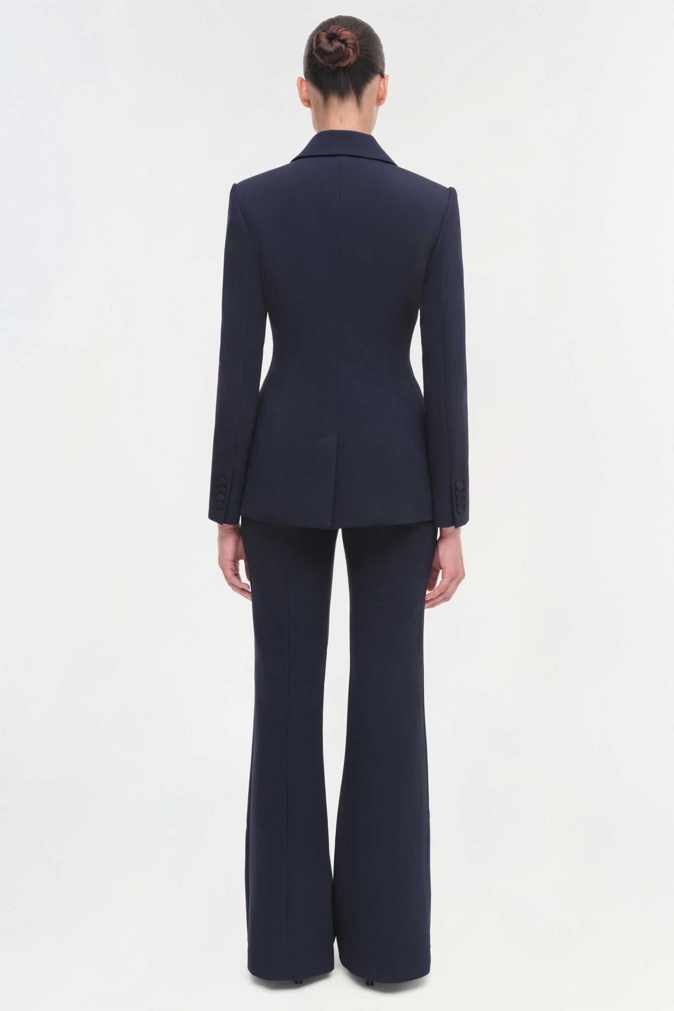 Navy blazer with long sleeves and notched collar, worn with matching wide-leg trousers, shown from back view.