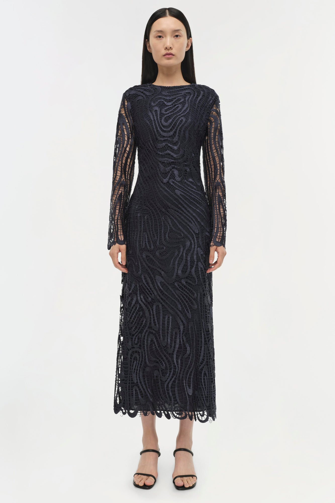 Black midi dress with abstract wavy pattern, sheer lace long sleeves, and scalloped hem.