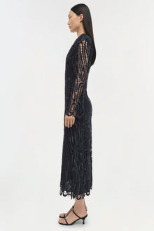 Black lace midi dress with long sleeves and cutout details, shown on model in profile view.