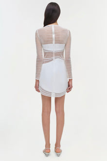 White mini dress with mesh long sleeves and cutout details at waist, shown from back view.