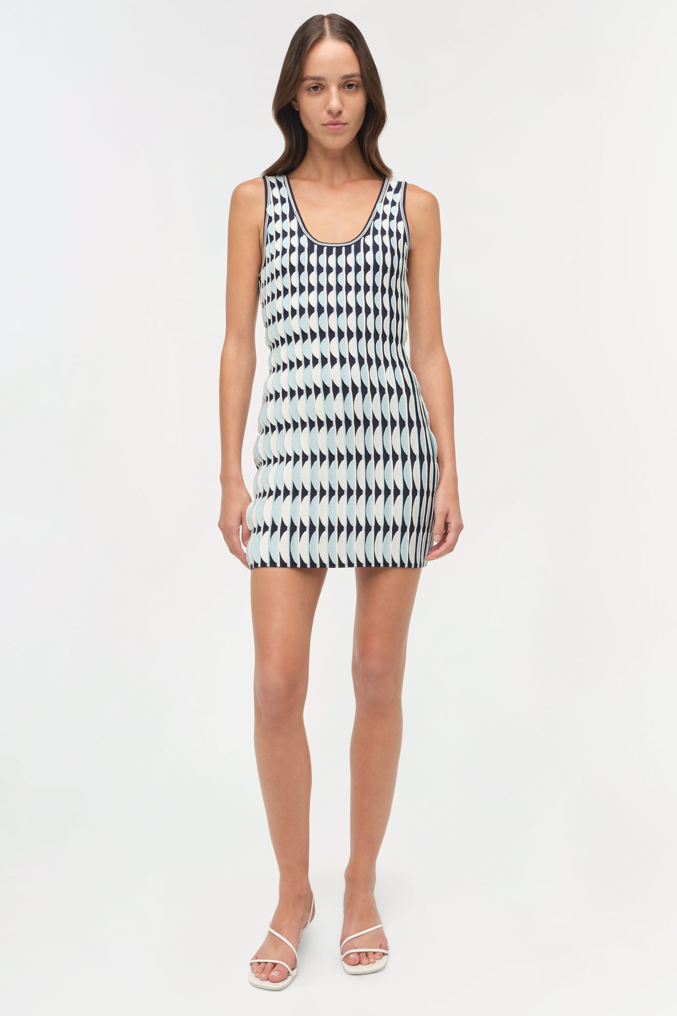 Sleeveless knit mini dress with scalloped edge trim and geometric arrow pattern in black and white.