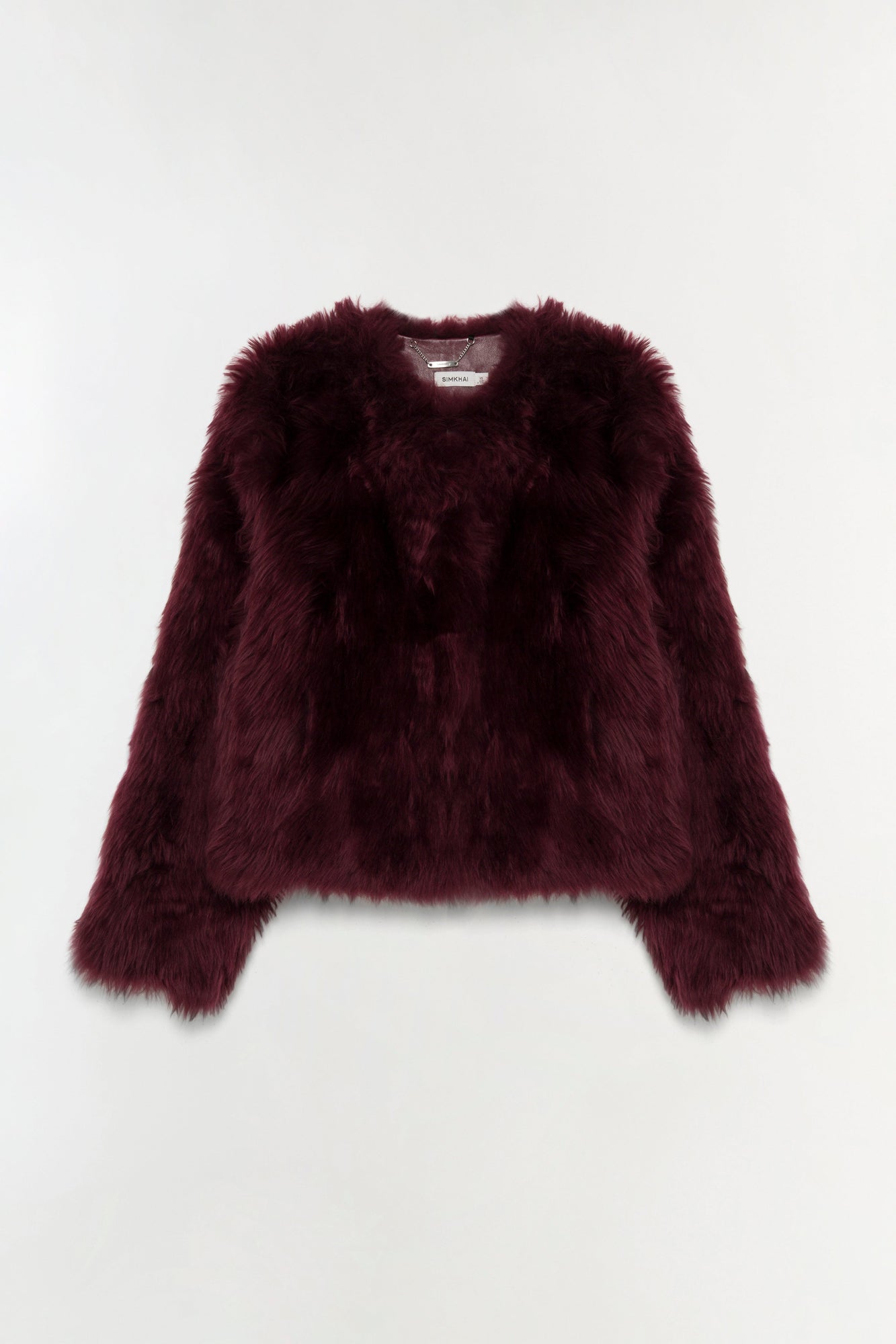 Burgundy shearling jacket with fuzzy texture and cropped fit, displayed on neutral background.