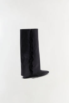 Black leather knee-high boot with fringe trim down the side seam and flat heel.