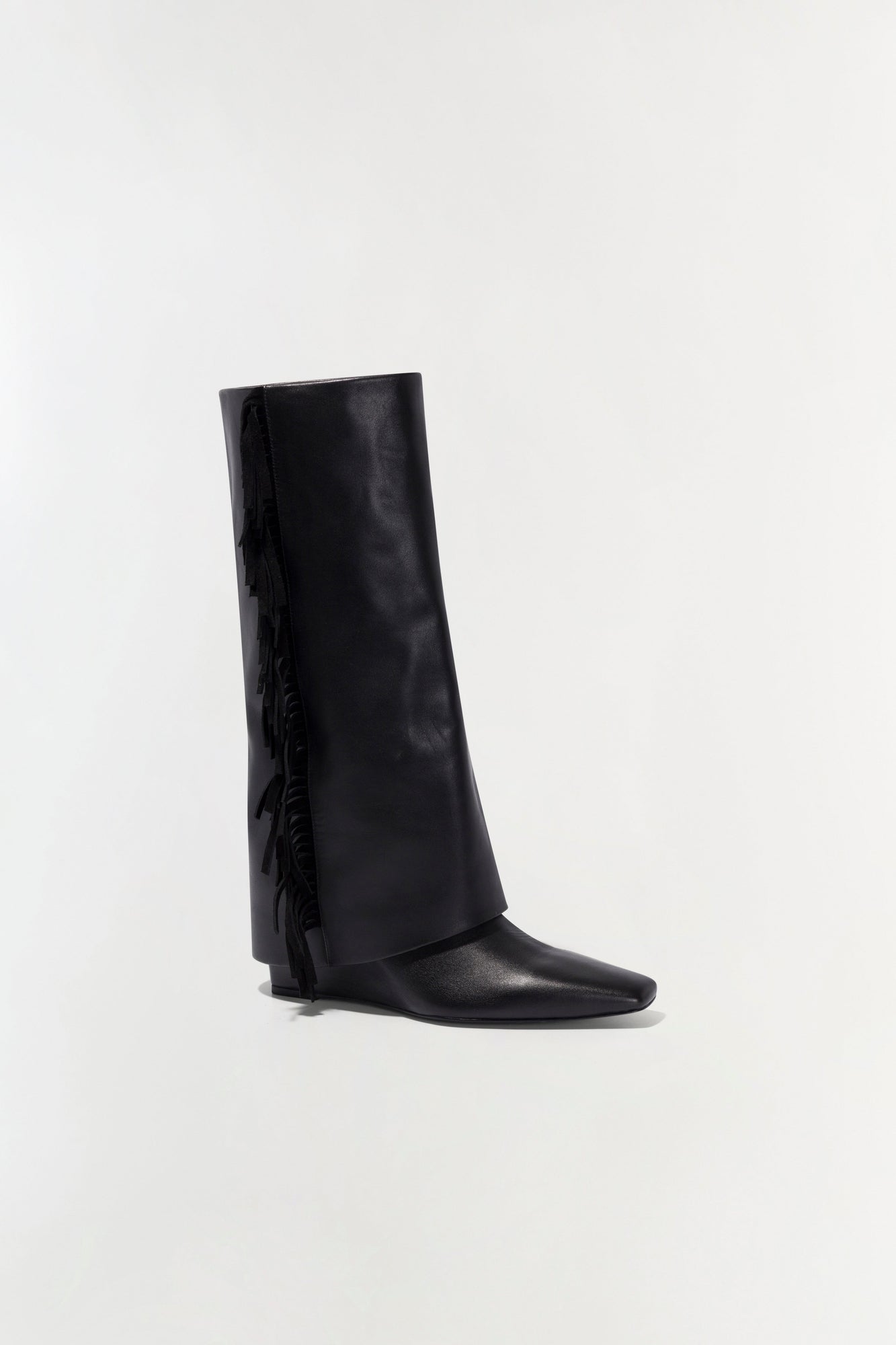 Black leather boot with fringe trim along the back shaft and a pointed toe.