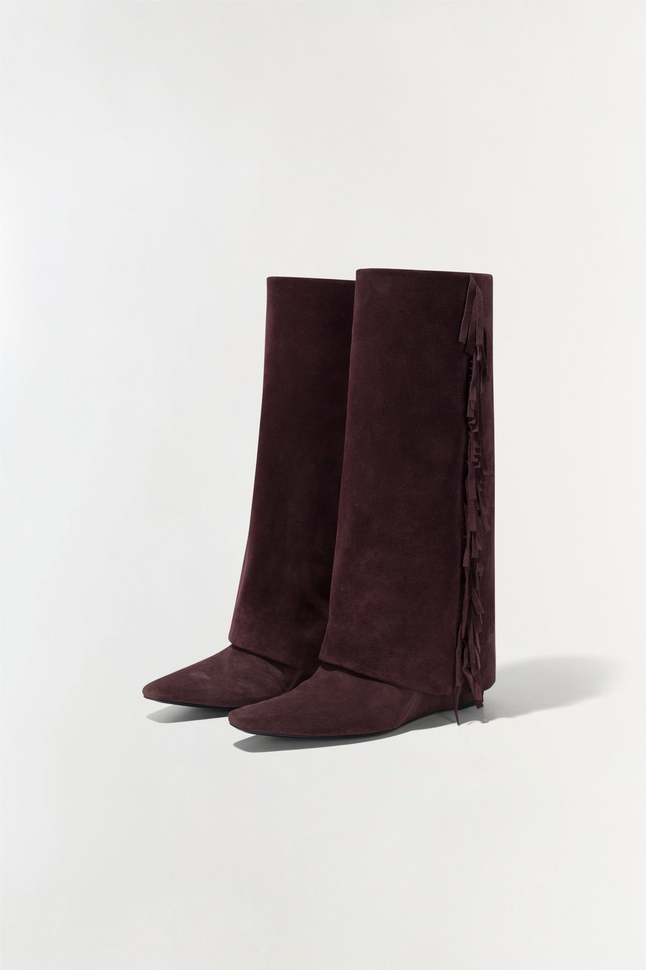 Burgundy suede boots with fringe trim down the back of the calf.