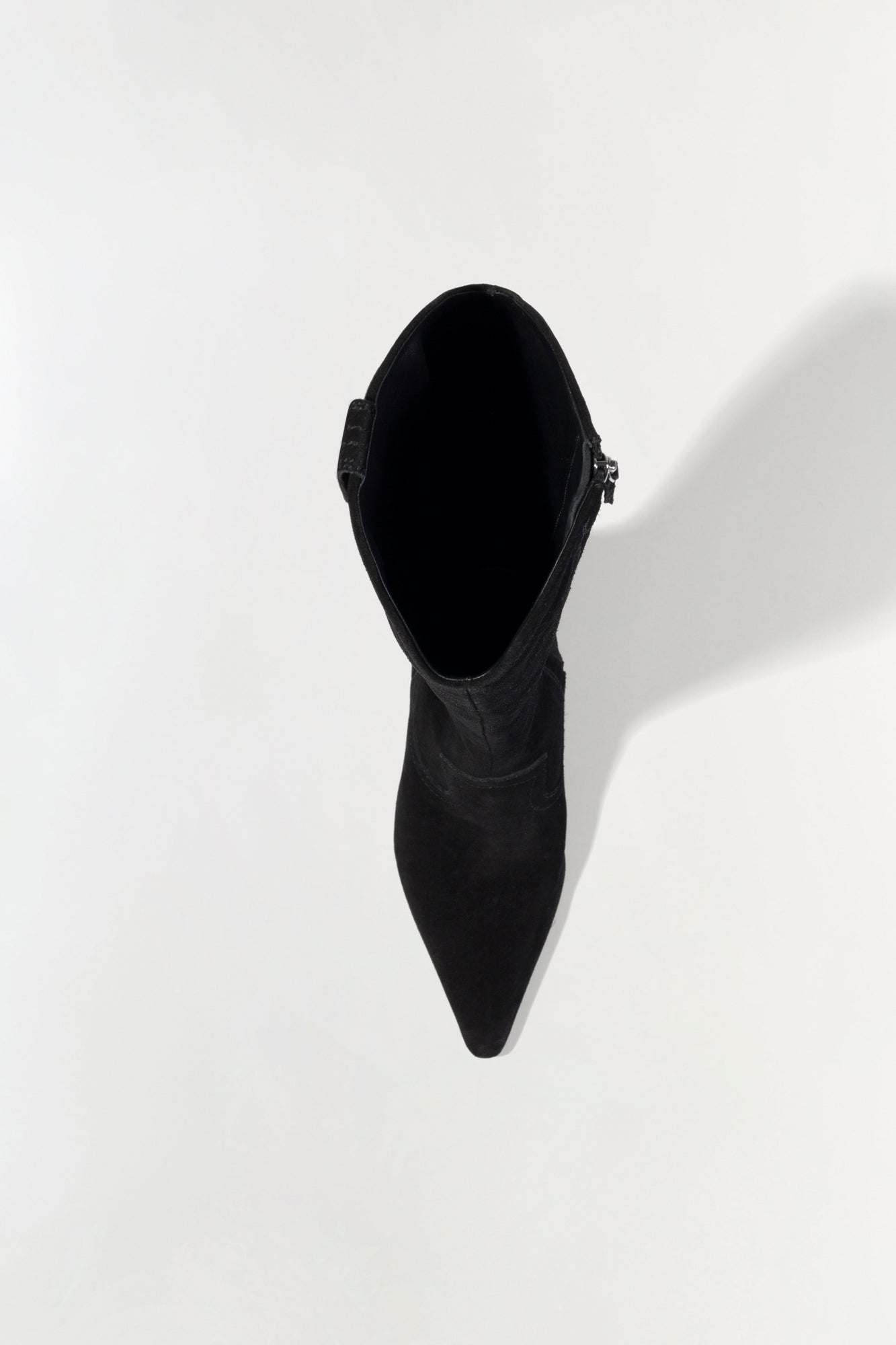 Black suede knee-high boot with pointed toe and side buckle detail, shown from above.