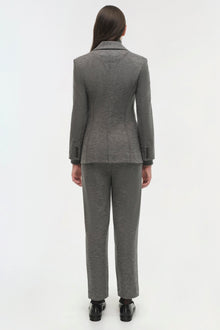 Gray wool blazer with notch lapels and matching trousers on model, shown from back view.