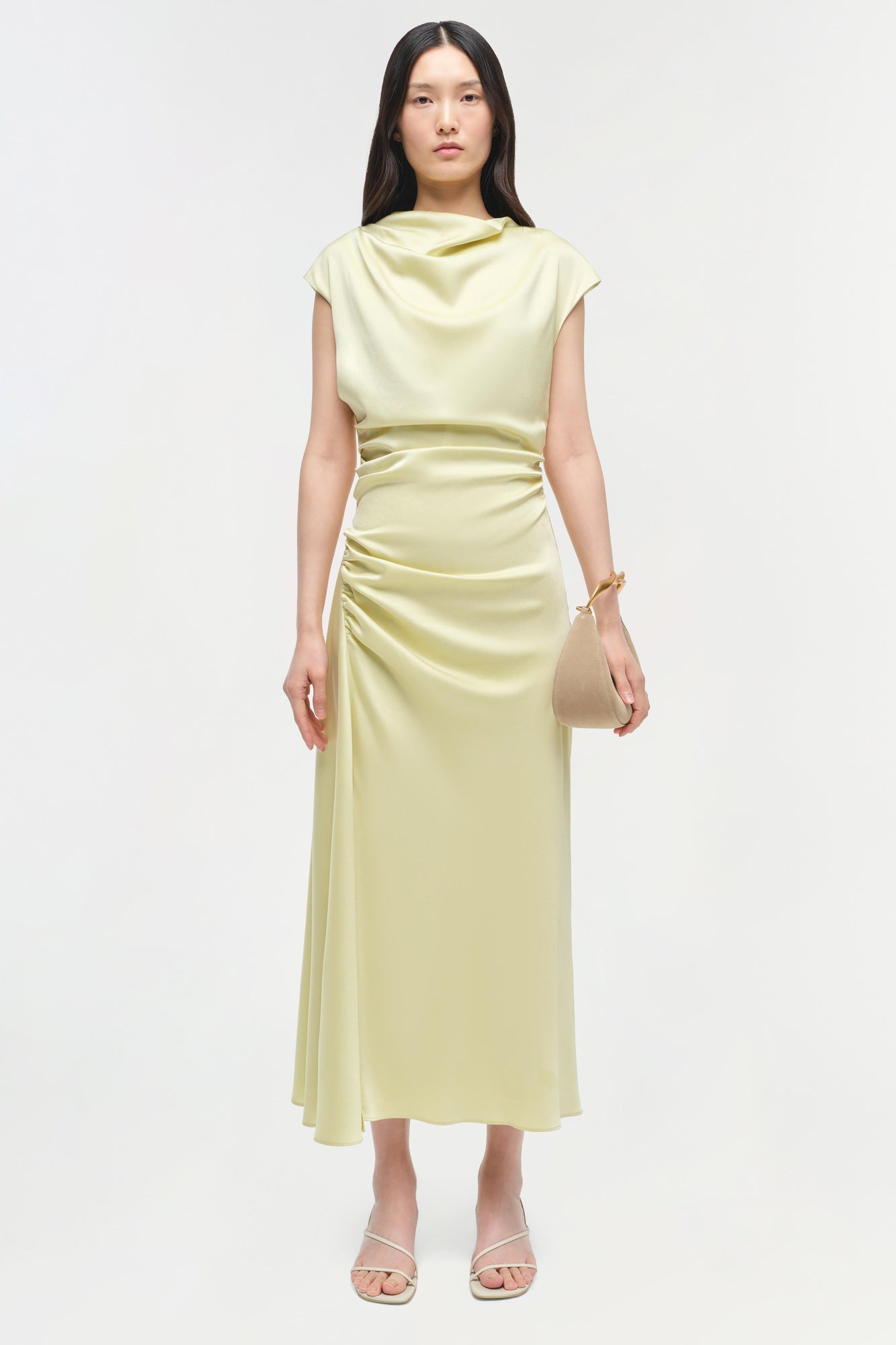 Pale yellow satin midi dress with cap sleeves, cowl neckline, and ruched waist detail on model.