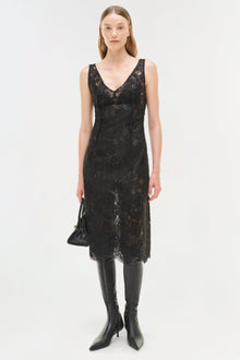 Black sequin lace sleeveless midi dress with V-neckline worn with black leather boots.