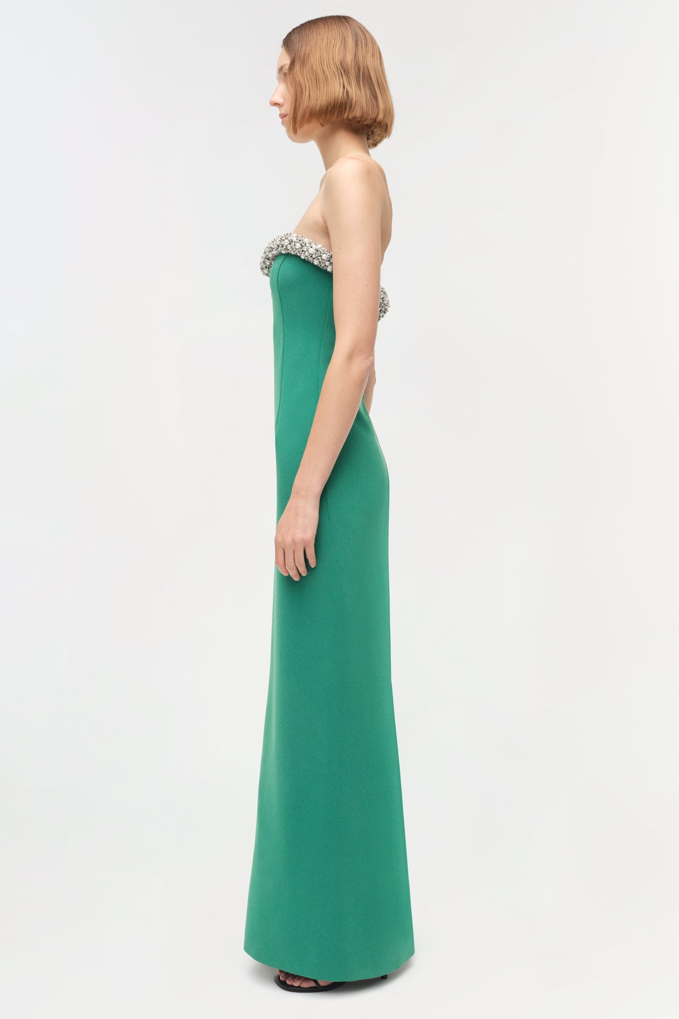 Emerald green strapless gown with beaded neckline detail and fitted silhouette.