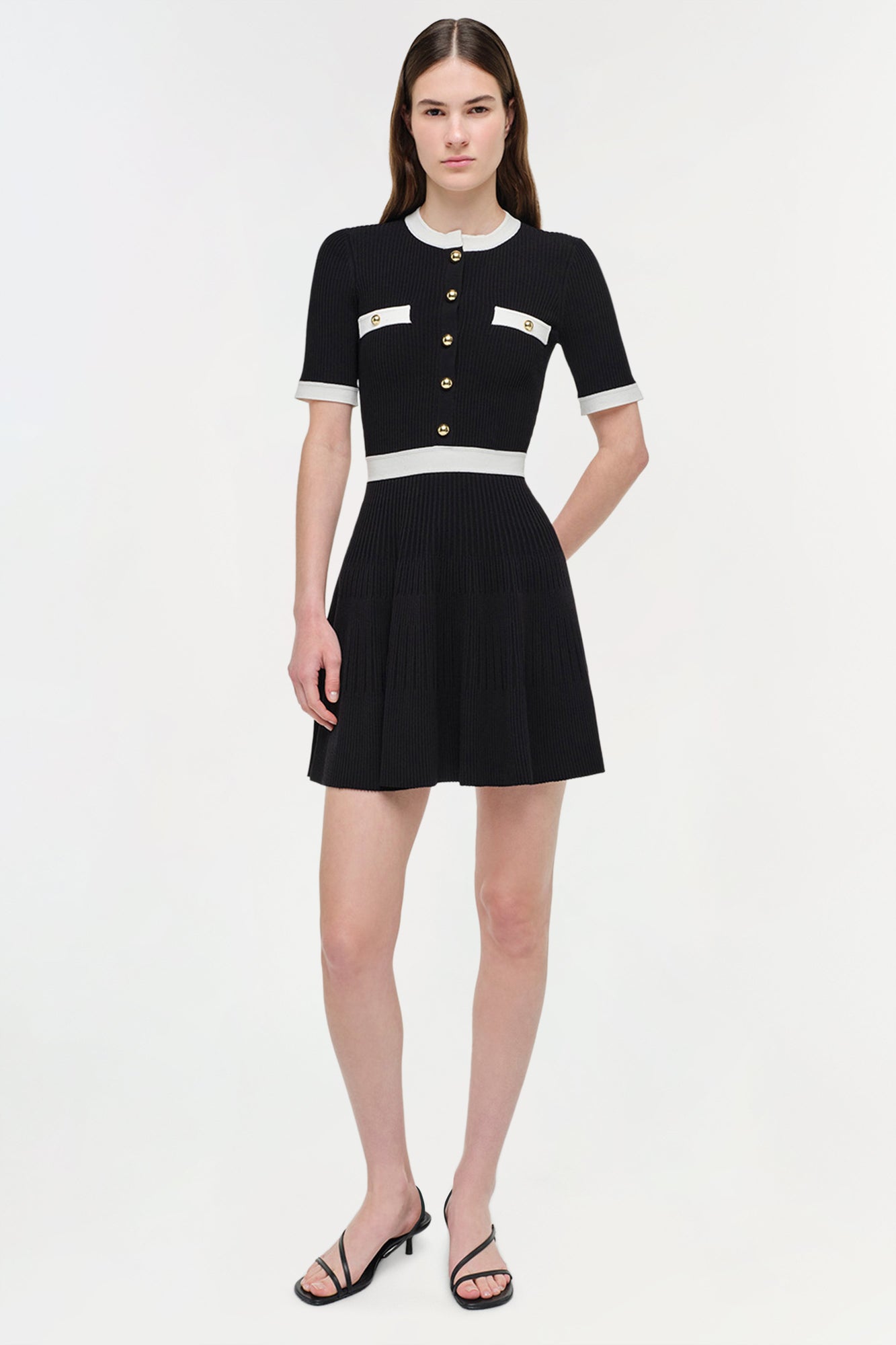 Black and white ribbed knit mini dress with short sleeves, button front, and waist stripe detail.