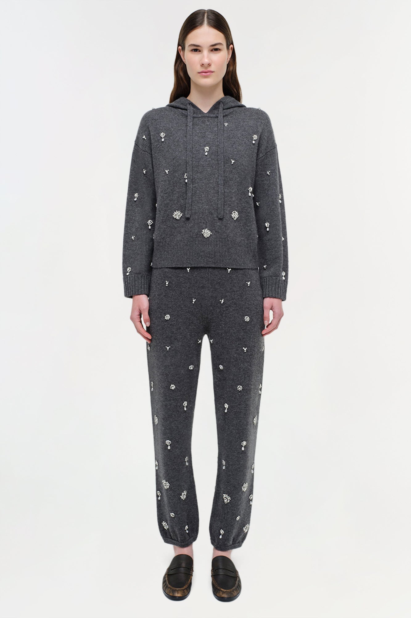 Charcoal cashmere hoodie and jogger set with scattered crystal embellishments throughout, worn with black loafers.
