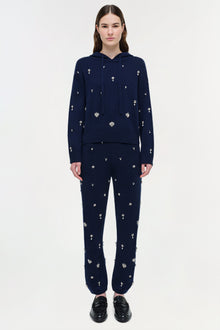 Navy cashmere hoodie with scattered crystal embellishments, paired with matching embellished pants.