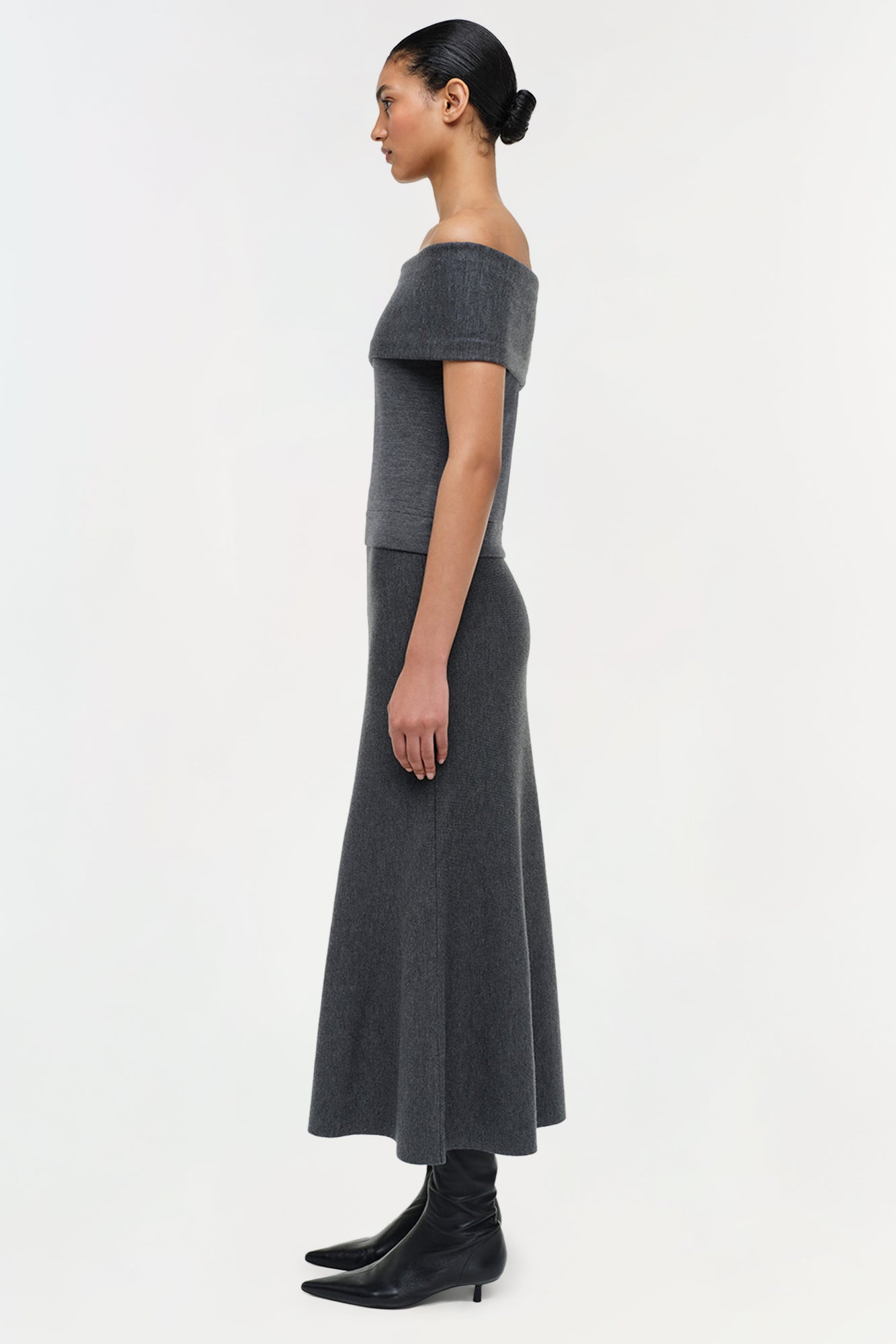 Charcoal gray wool off-shoulder top with short sleeves and fitted bodice, styled with a matching midi skirt.