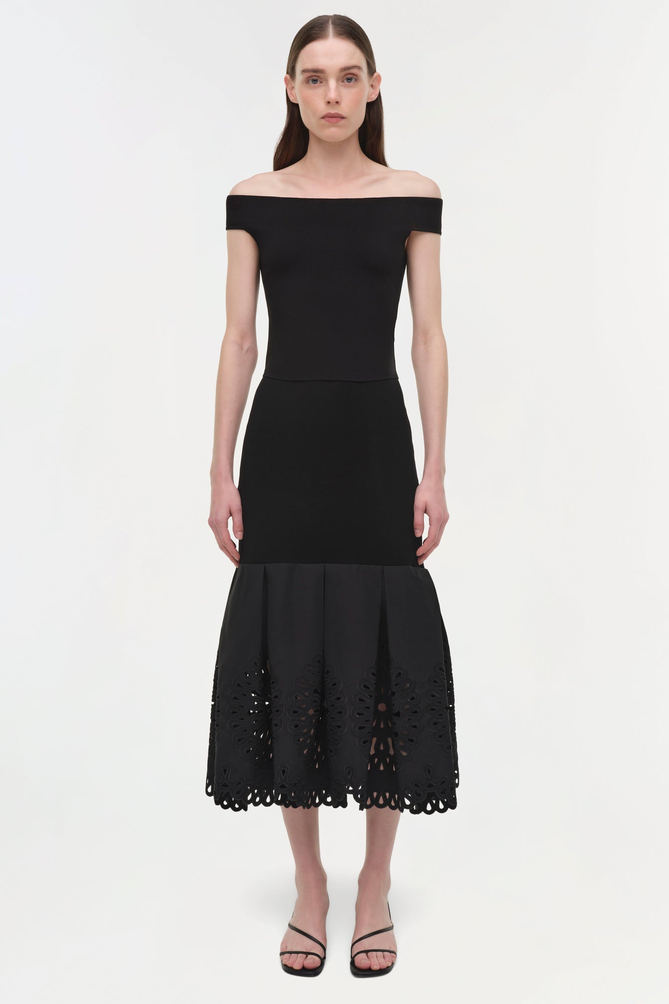 Black knit midi skirt with embroidered cutout hem detail, worn with off-shoulder top.