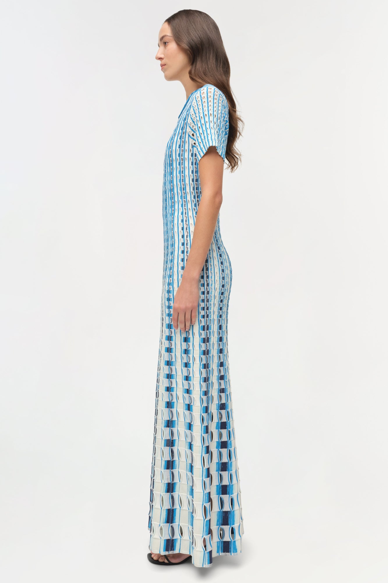Blue and white knit midi dress with eyelet pattern and short sleeves, shown on model in side profile.