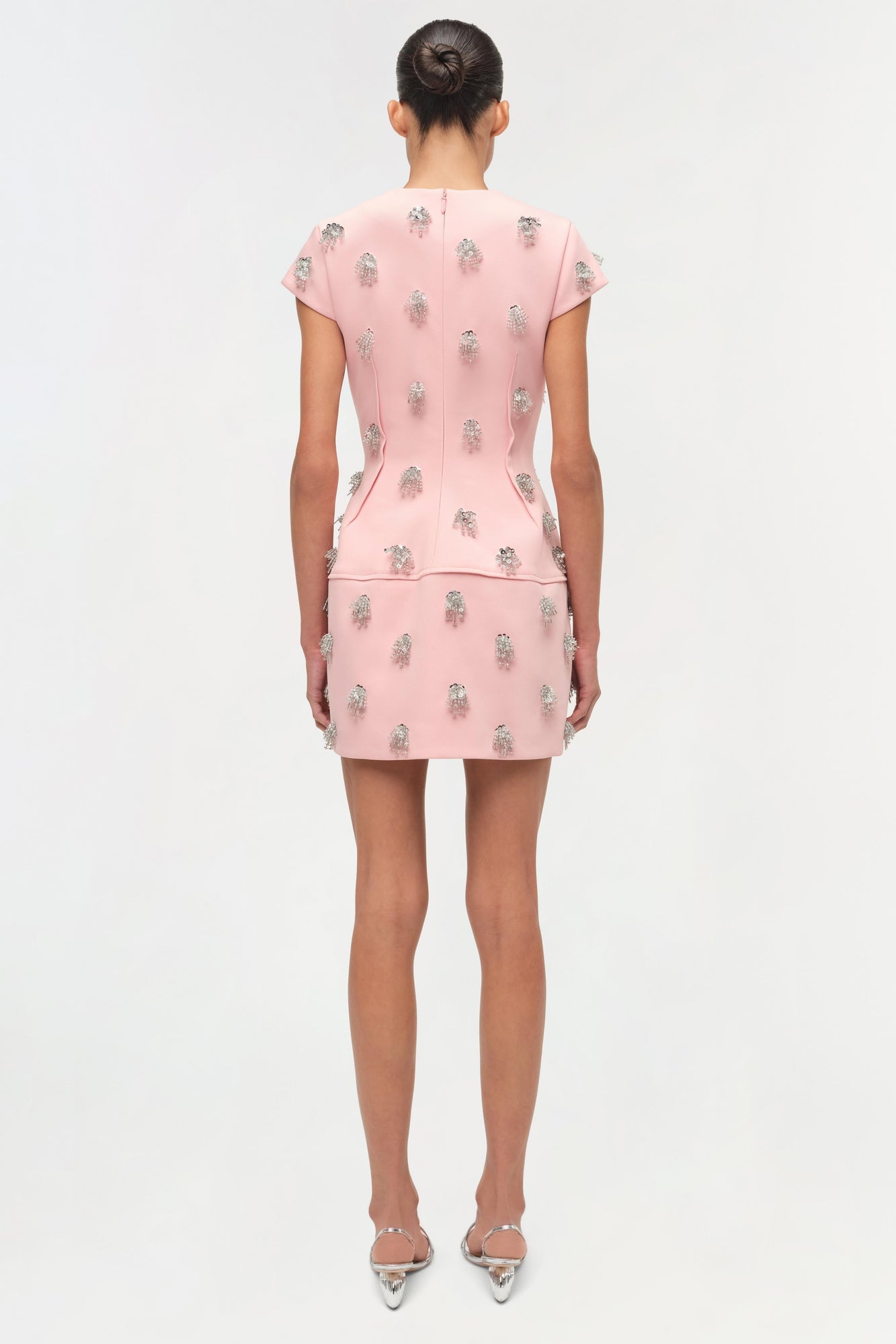 Pink mini dress with silver beaded embellishments scattered throughout, short sleeves, and seamed waist detail.
