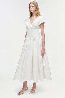 Woman wearing white cotton midi dress with short sleeves, V-neckline, and fitted waist with full skirt.