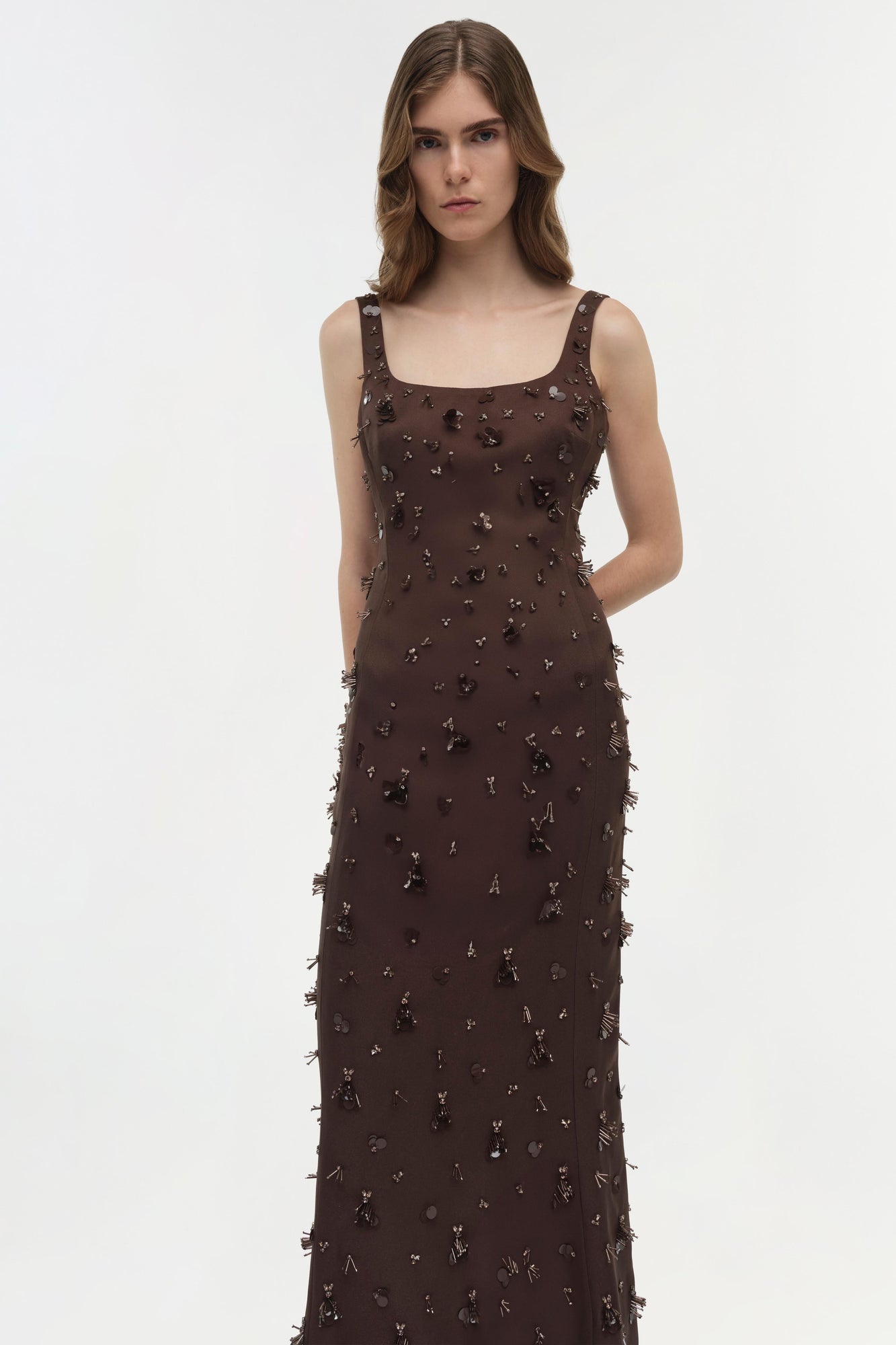 Brown sleeveless gown with scattered metallic beading and fringe detailing throughout.