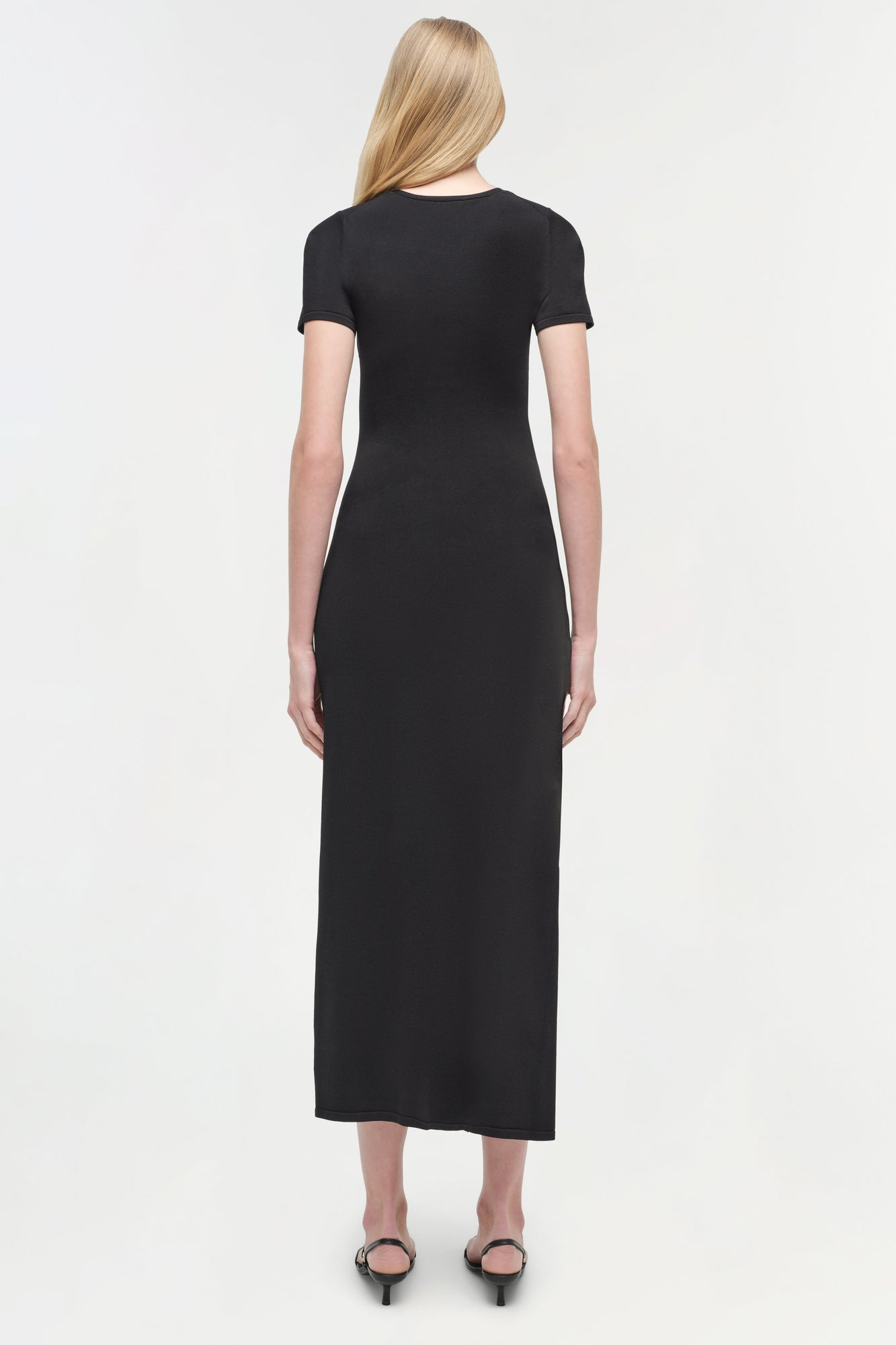 Black knit midi dress with short sleeves on model, shown from back view.
