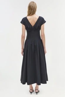 Black cotton midi dress with short sleeves, V-back neckline, and full pleated skirt, shown on model from behind.