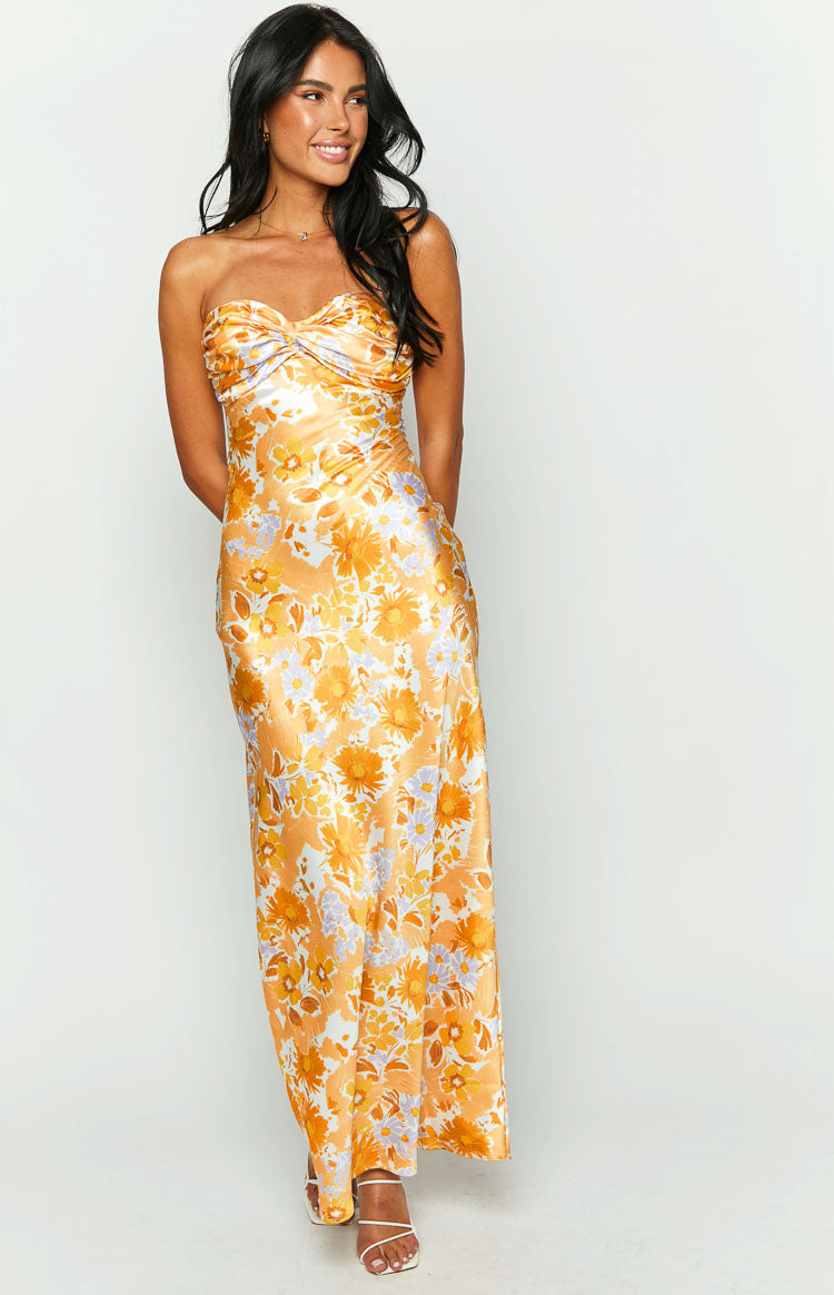 Front view of an orange floral strapless maxi dress with a twisted bust and ruched side detail