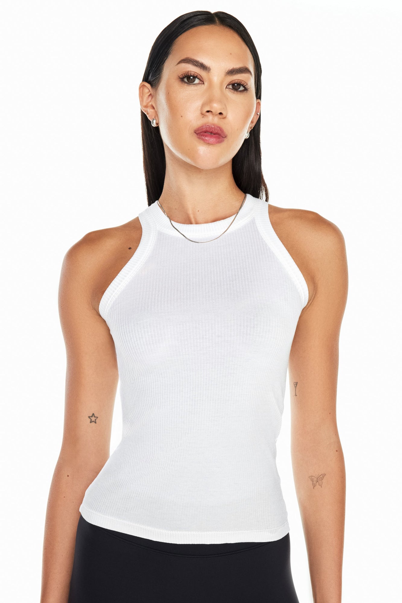 Model wears a high neck white tank. 