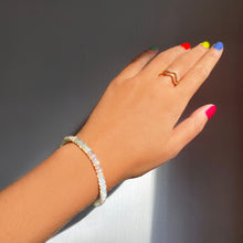 Shimmering beaded bracelet made of faceted opals in shades of milky white and clear on a gold linking lobster clasp.