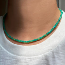 Shimmering beaded necklace made of faceted opals in shades of light green on a gold linking ovals clasp.