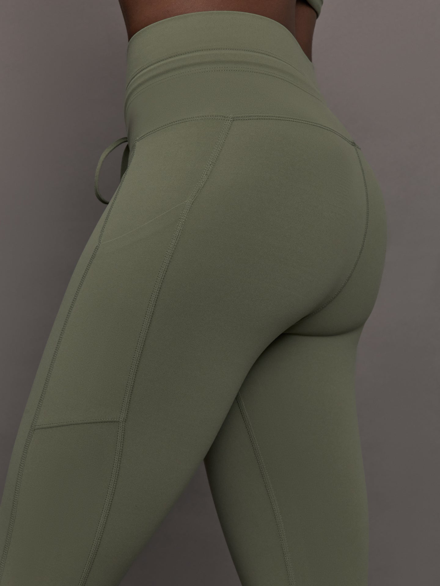 Close-up of waistband and pocket detail on Melt High Rise Sport Pocket Legging Moss.