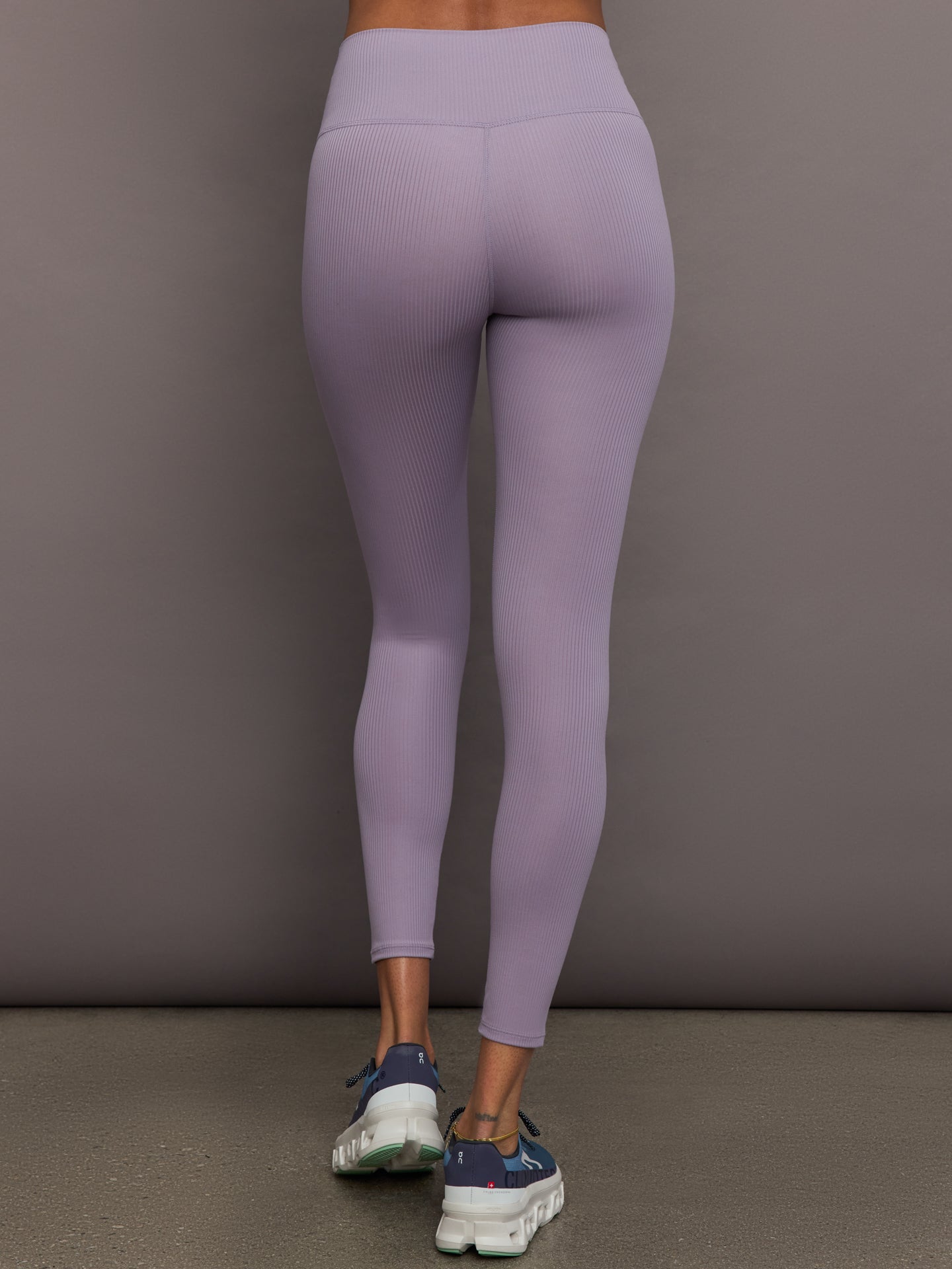Model wears lavender grey, high-rise ribbed leggings with a fitted, full-length silhouette.